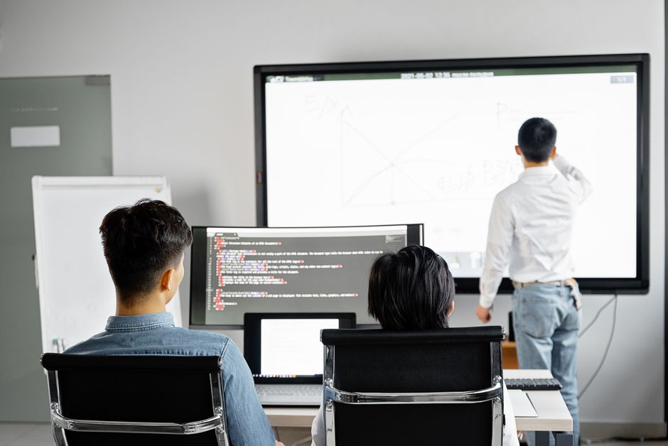 Equipo realizando una presentación de negocios con tecnología en una oficina moderna.