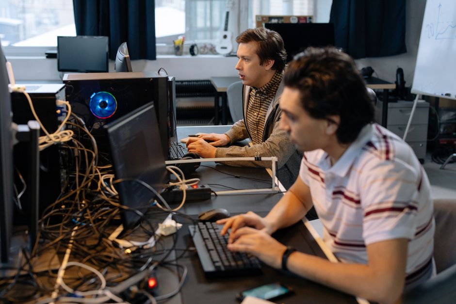 Programadores hombres trabajando en computadoras en una oficina moderna