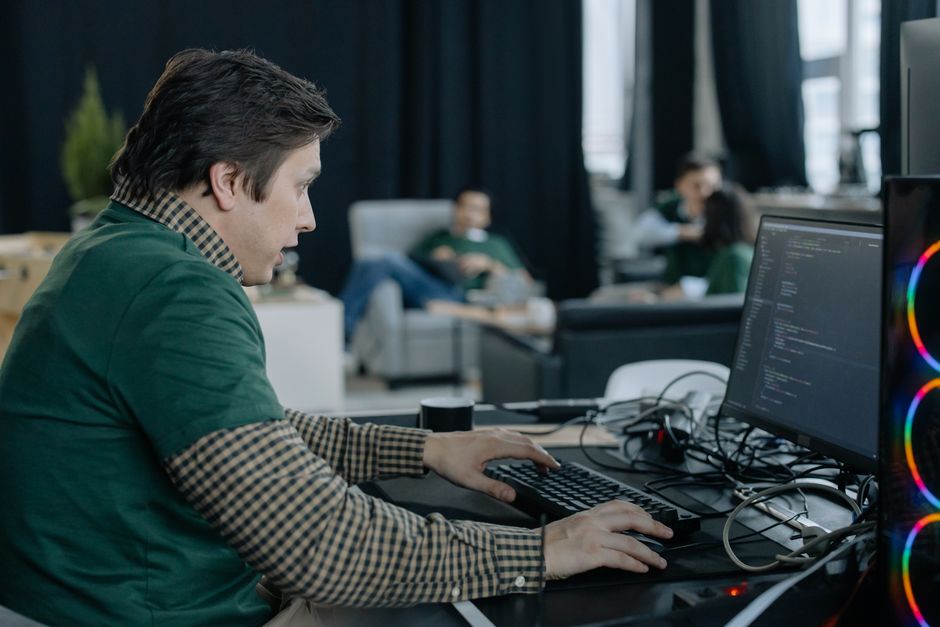 Programador concentrado en escribir código en una oficina contemporánea